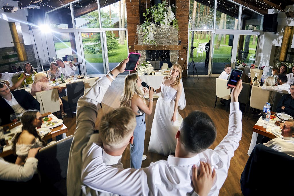 A joyful indoor wedding reception with guests, music, and dancing.